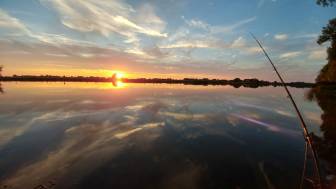 Vorschaubild Angel in der Havel bei Sonnenuntergang, Himmel spiegelt sich atmosphärisch im Wasser