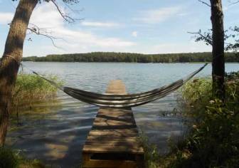 Vorschaubild Steg ragt in den Kyritzer Untersee der Kyritzer Seenkette mit Hängematte zwischen zwei Bäumen im Sommer